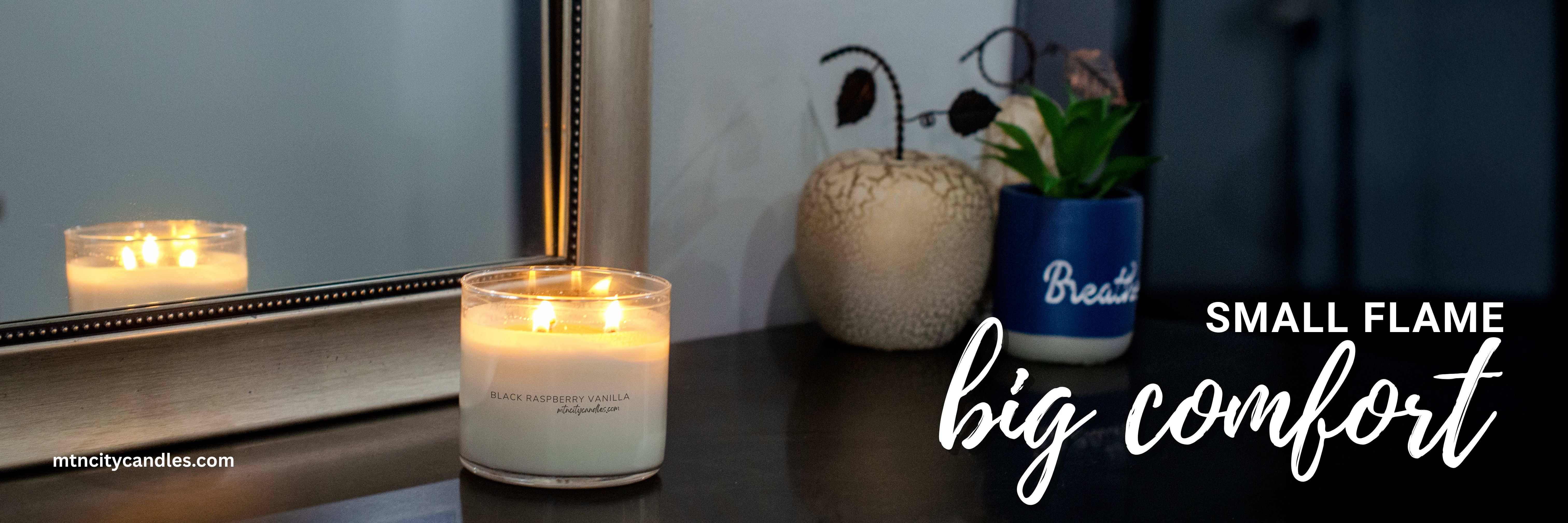 3 wick candle in front of a mirror in the dining room